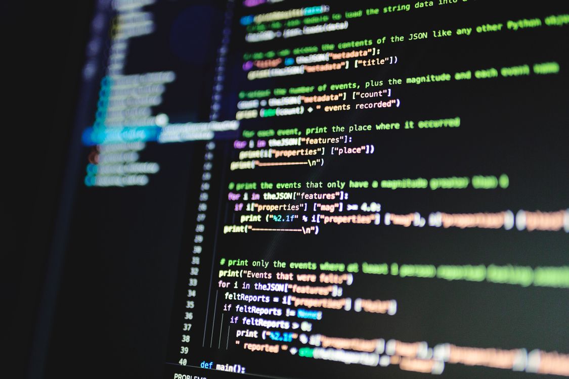 Nahaufnahme von buntem Programmcode auf einem Bildschirm, Symbol für die Ebene hinter der KI-Textgenerierung