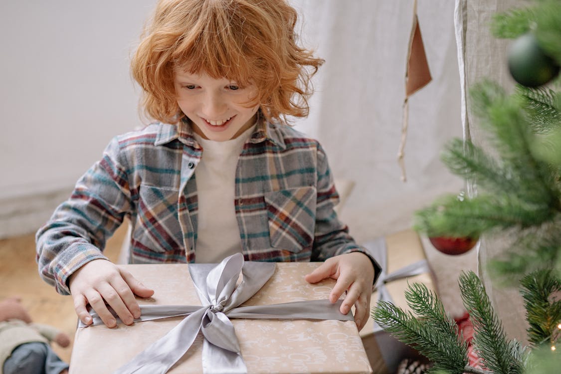 Kind uberrascht und freudig mit einem Geschenk in den Handen
