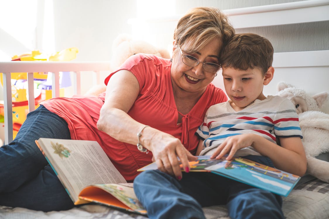 Oma liest zwei Kindern aus einem Buch vor
