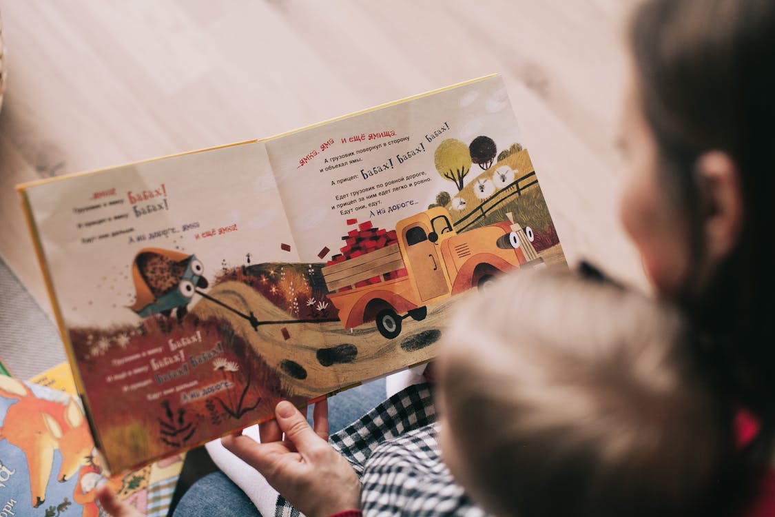Mutter liest Kleinkind aus illustriertem Buch vor