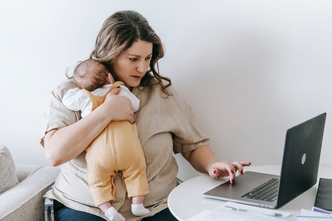 Eine berufstätige Mutter mit ihrem Baby — Fürsorge und Erschöpfung gehen oft Hand in Hand