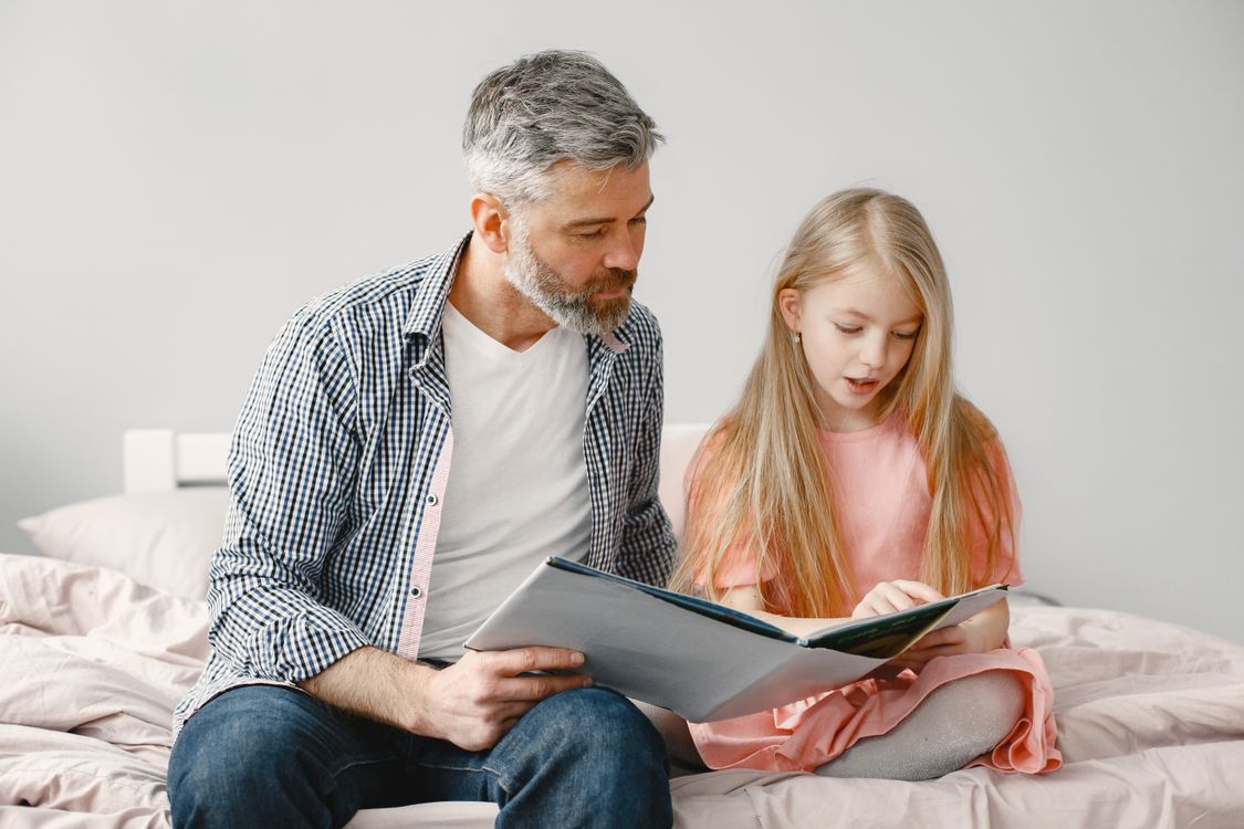 Vater liest seiner Tochter eine Gutenachtgeschichte vor