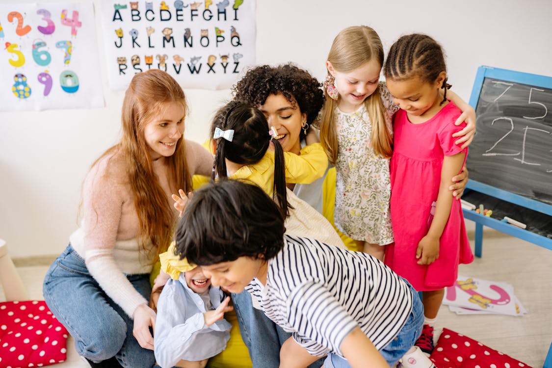 Kinder im Klassenzimmer mit Alphabet-Poster an der Wand
