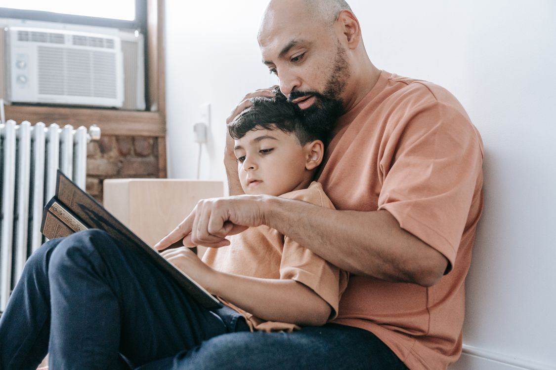Ein Vater liest seinem Sohn ein persönliches Kinderbuch vor