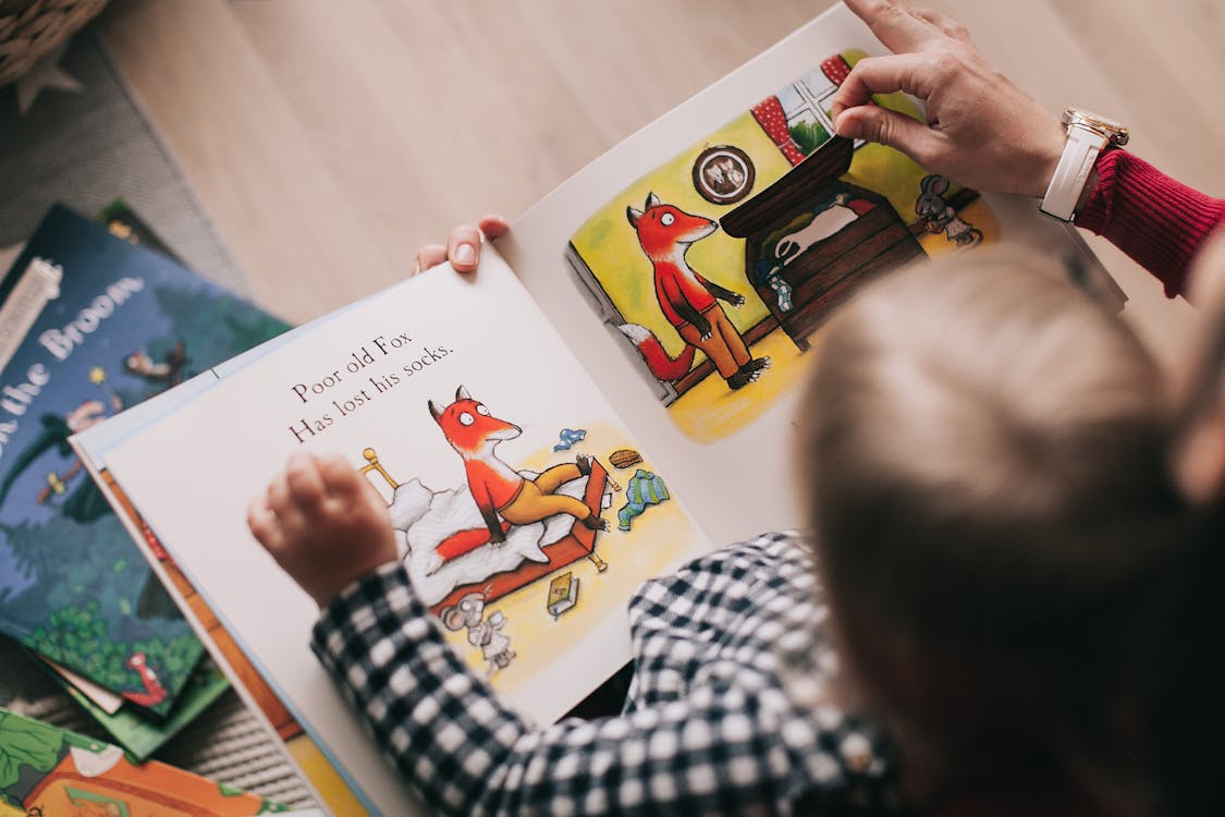 Kind betrachtet ein Bilderbuch mit einer eigens gestalteten Fuchsfigur
