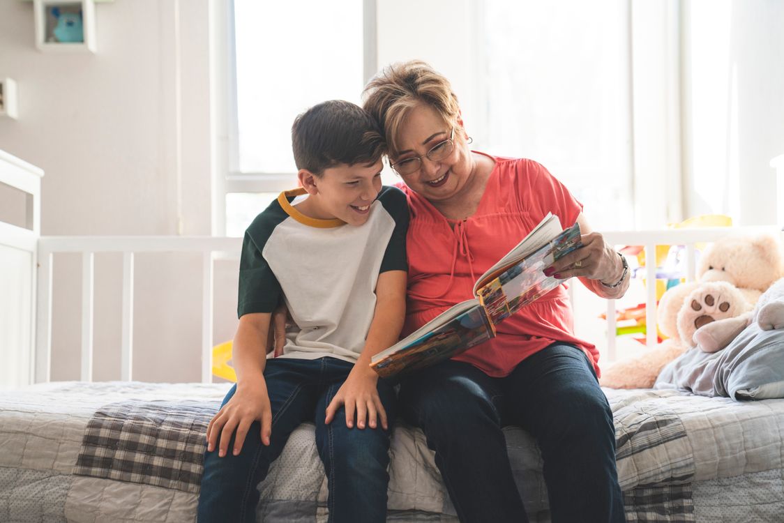 Eine Oma liest ihrem Enkel vor - wiederholtes Lesen desselben Buchs baut Wortschatz zuverlässiger auf als immer neue Bücher