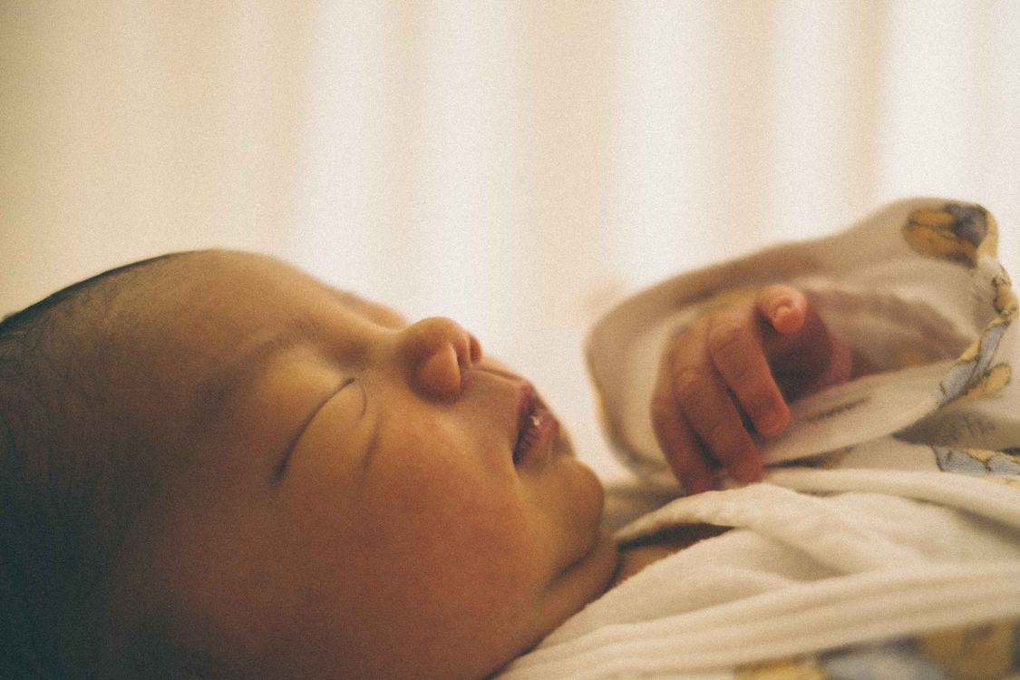 Neugeborenes Baby schläft friedlich in einem Bettchen